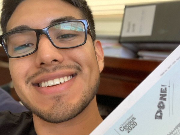 Person smiling with filled out Census 2020 form