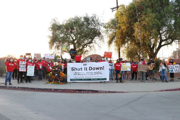 Protestors with "Shut It Down!" sign